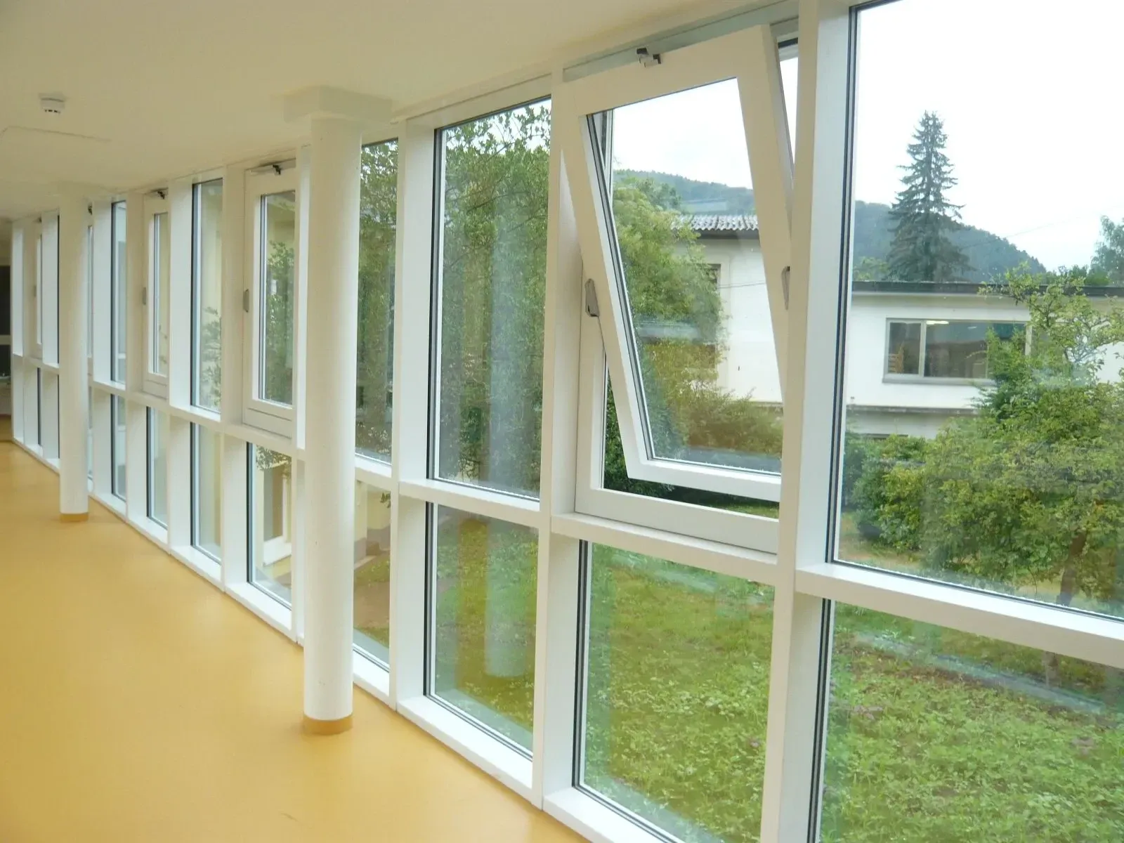 Flur mit raumhoher Glasfassade und gekipptem Fensterflügel