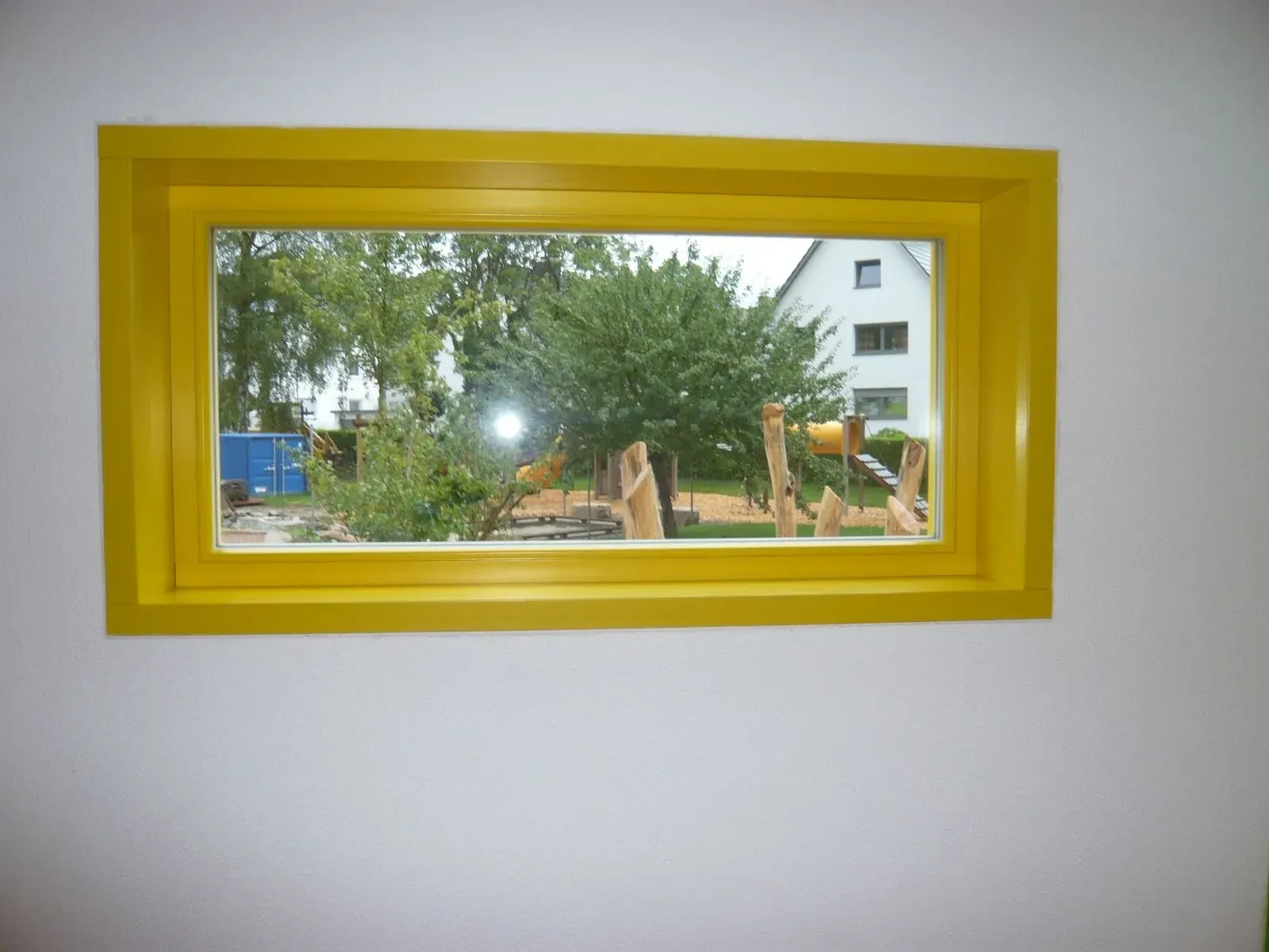 Festverglastes Holzfenster mit gelber Laibung, Innenansicht