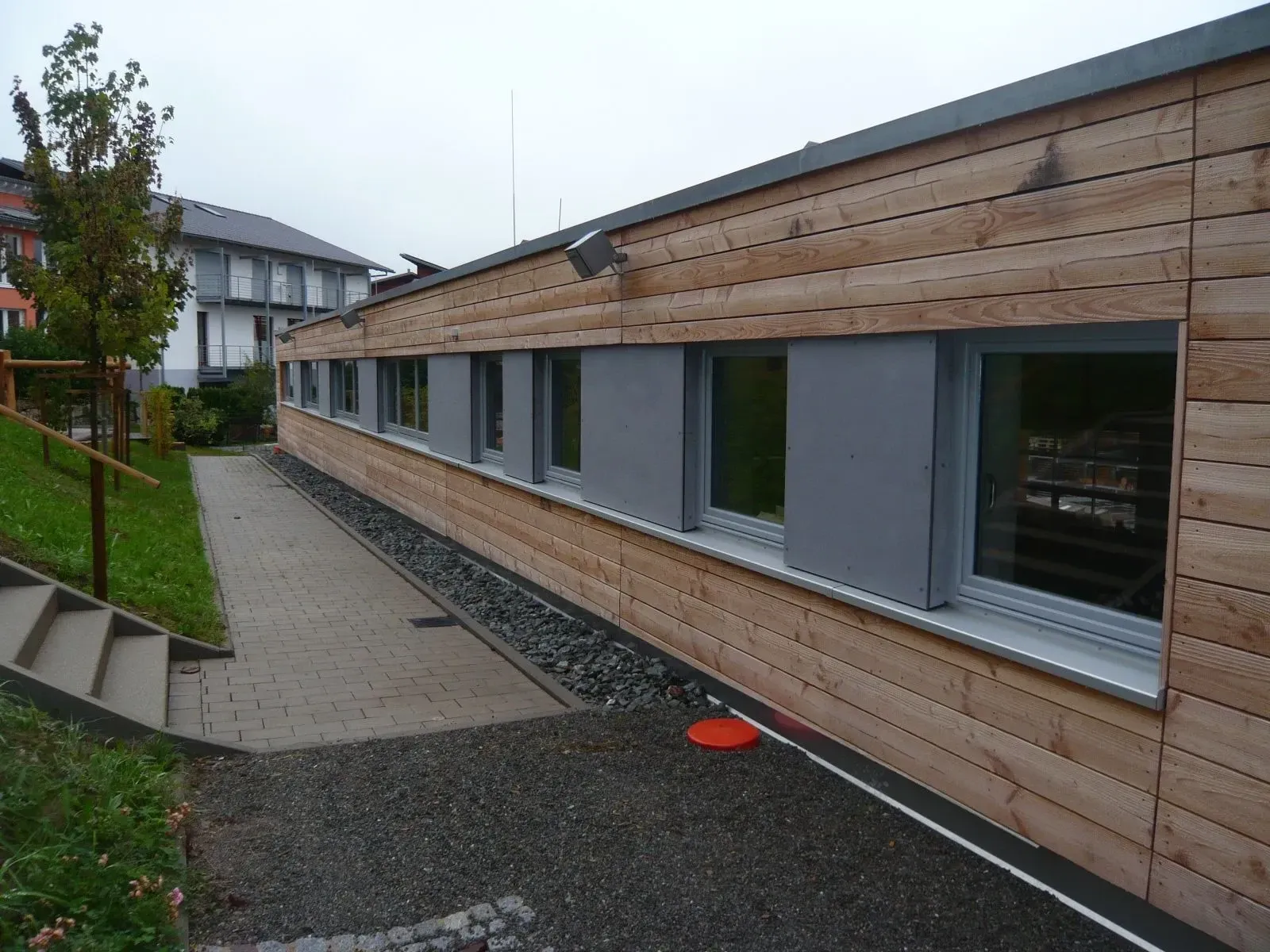Flachbau mit Holzfassade und Fensterband