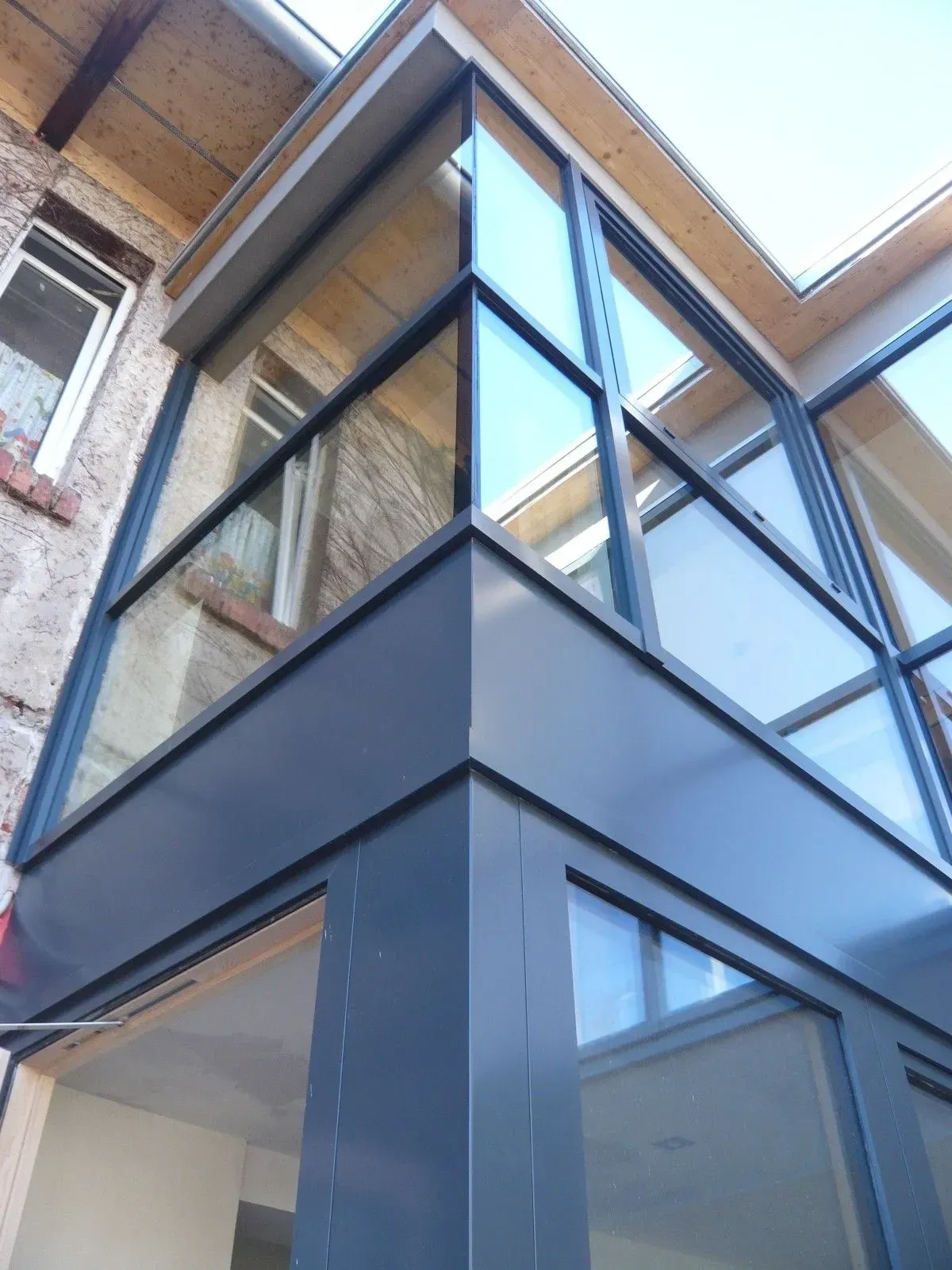 Detail einer Eckverglasung mit anthrazitfarbener Aluminiumschale