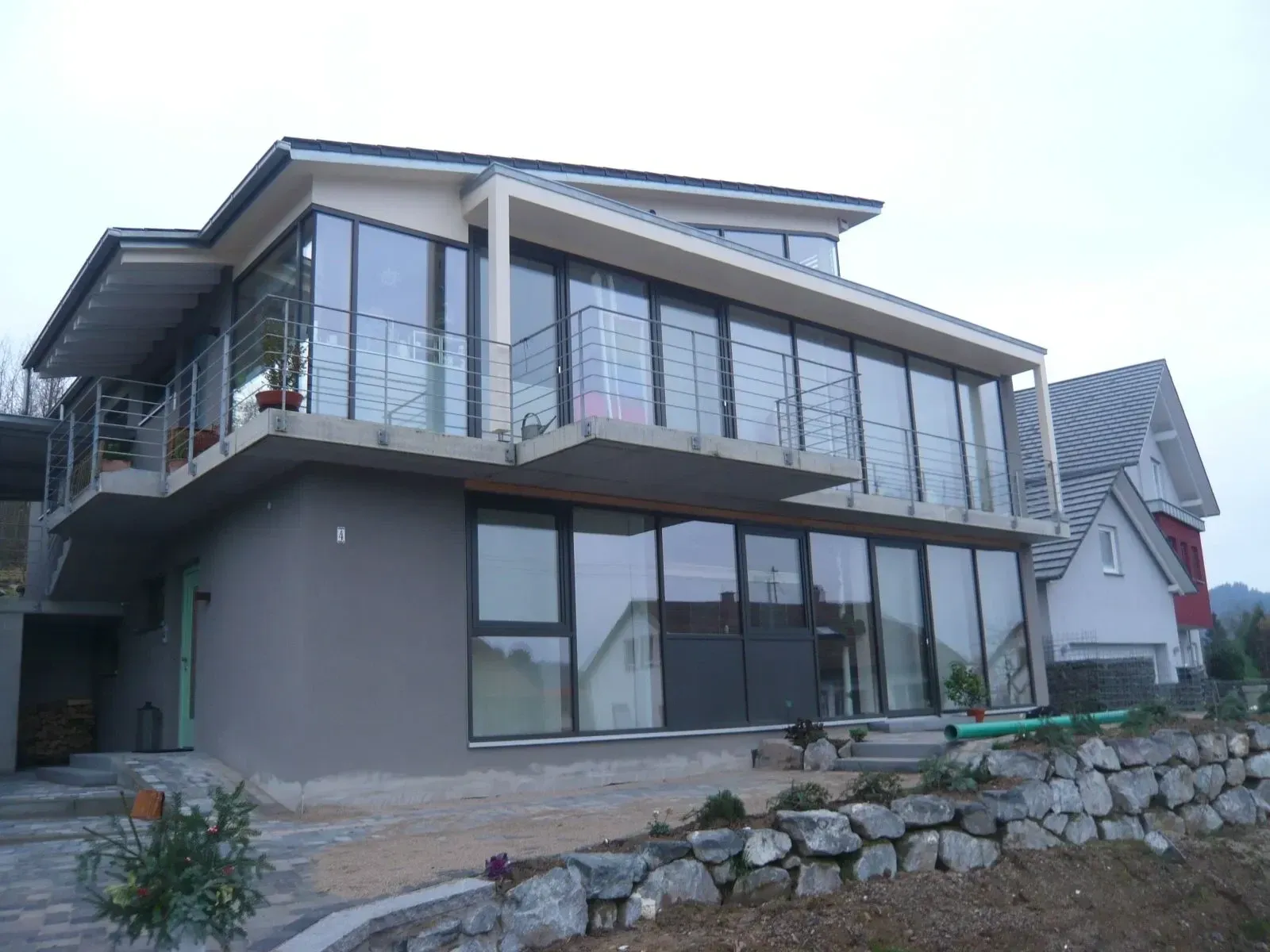 Modernes Wohnhaus mit Pfosten-Riegel-Fassade und umlaufendem Balkon