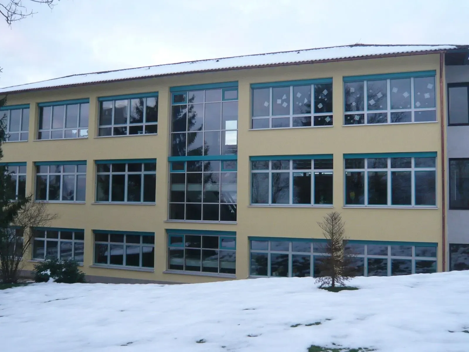 Schulgebäude mit großen Fensterelementen im Winter